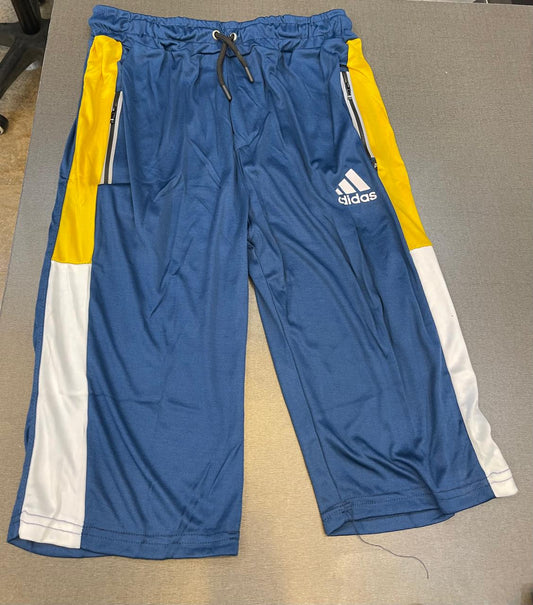 Blue Adidas athletic shorts with yellow and white side panels, laid flat on a gray surface.
