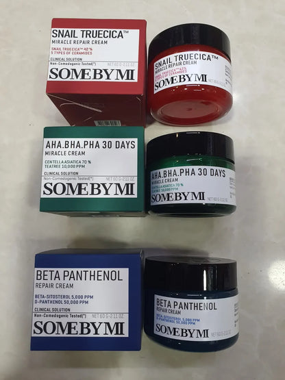 Collection of SomeByMi skincare products including jars and boxes on a light background