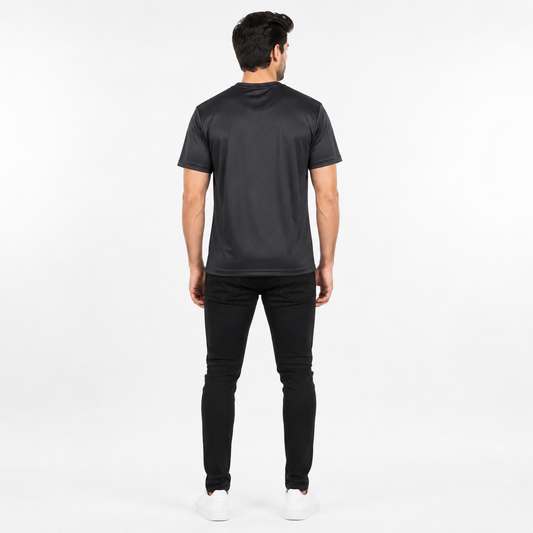 A man viewed from behind wearing a black short-sleeve t-shirt, black pants, and white sneakers against a plain white studio background.