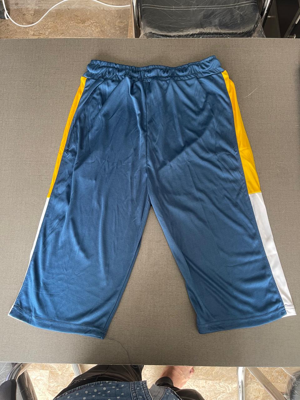 Blue athletic shorts with yellow and white side stripes, laid flat on a gray surface.