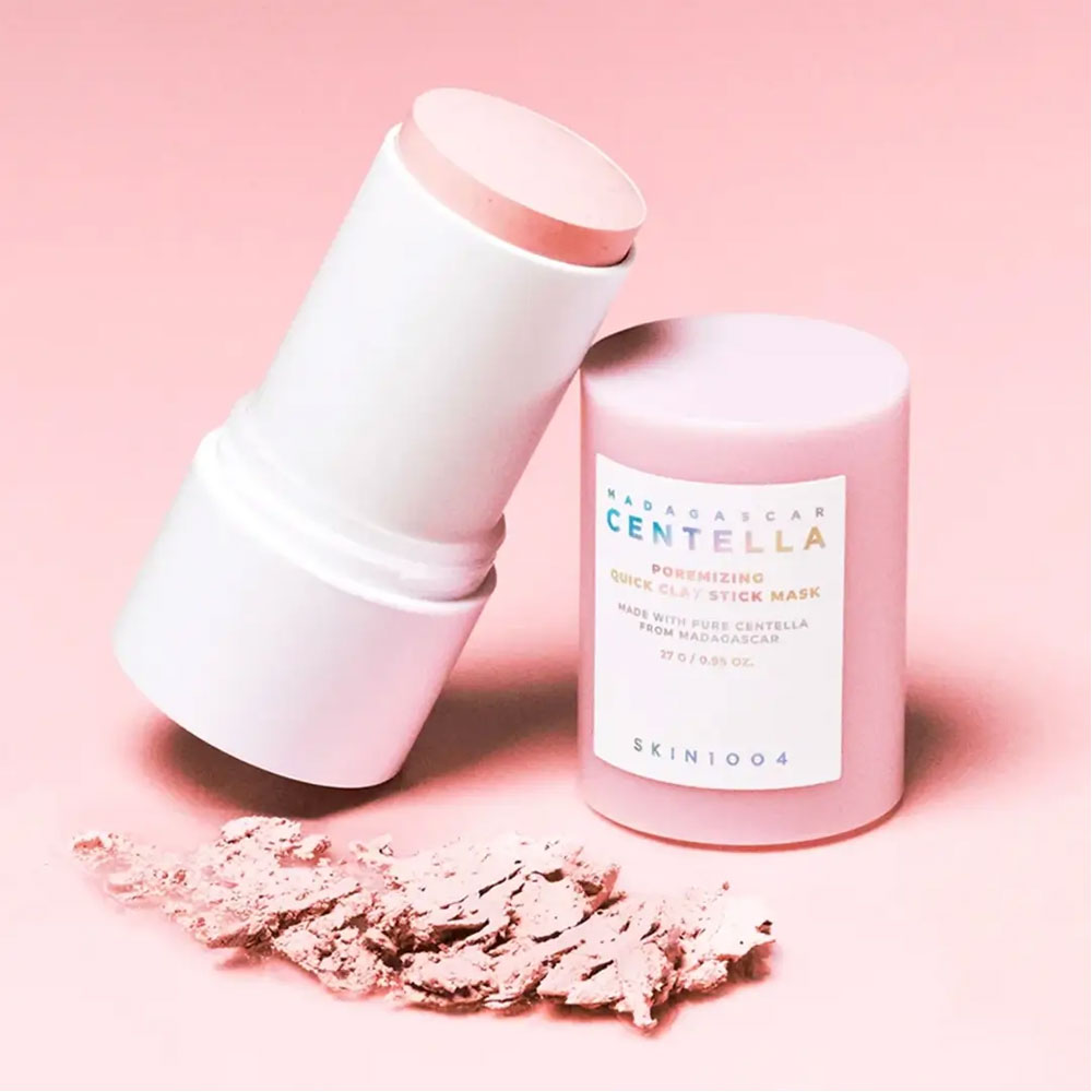 Pink skincare stick and container on a pink background